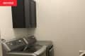 Washer and dryer with a set of black cabinets overhead