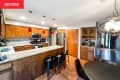 Kitchen with brown wood cabinetry, peninsula, and flooring before renovation.
