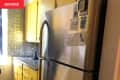 Refrigerator in kitchen before renovation.