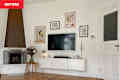 Before lead photo of white living room with hanging art, a TV and fireplace