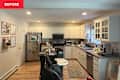 Kitchen with white cabinets and many items on countertops