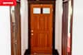 Entryway with wood door, flooring, and moulding/molding before redecorating.