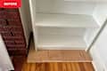 White Ikea bookshelf in corner of living room.