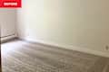 Empty room with light gray carpet, white walls, and a baseboard heater along one wall.