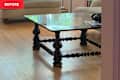 Glass coffee table with black legs before transformation into ottoman