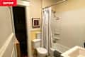 Small bathroom with a shower curtain, toilet, and sink, featuring yellow walls and framed artwork.