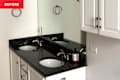 Black vanity top in bathroom before renovation.
