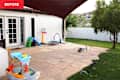 Patio area with a stone floor, children's toys, a small slide, a trampoline, and a grassy yard.