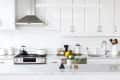 Modern kitchen with white cabinets, subway tile backsplash, stainless steel stove, and a vase of yellow flowers on the counter.