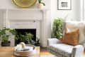 A white brick fireplace with a large gold plate on the mantel