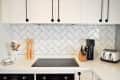 A white tile backsplash in a chevron pattern