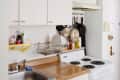 Small kitchen with white cabinets, electric stove