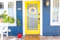 Front entrance of a blue house with white trim and a yellow door