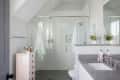 Bathroom with glass shower, gray countertop, pink dresser, and floral decor.