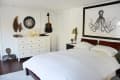 Bedroom with white dresser, wall art of an octopus, acoustic guitar, and decorative items on display.