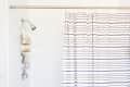 White shower with gold caddy and striped shower curtain