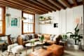 boho living room with exposed beams and white-washed brick walls