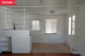 Small room with white walls, built-in shelves, and a door with blinds. Brown wooden floor and beige carpet area.