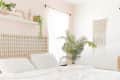 a bedroom with a pale pink accent wall