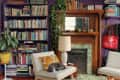 A purple living room with a purple bookcase and a large wooden fireplace