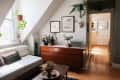 Cozy living room with a white sofa, wooden dresser, hanging plants, framed art, and a Marshall speaker.