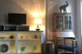 Living room with a TV on a console, lit lamp, decorative elephant, and wooden cabinet.
