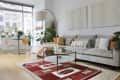 Living room with gray sofa, arched floor lamp, and red southwestern-style rug