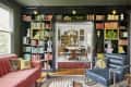 A transition between a living and dining room covered with a built-in black bookshelf