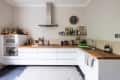 L-shaped butcher block counters in a kitchen with no upper cabinets