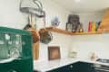 Kitchen with dark lower cabinets and green Smeg