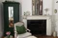 Marble fireplace, green wardrobe, and tan armchair