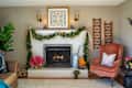 Cozy living room with a decorated fireplace, garland, poinsettias, orange armchair, and a framed artwork above.