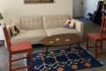 Living room with blue rug and two red chairs