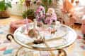 A glass coffee table with flowers and candles on top