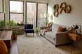 Living room with large windows and hexagonal shelves hanging on wall