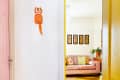 white hallway with kitcat clock and view into living room