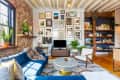 Living room with exposed brick, gallery wall, and built in bookshelf