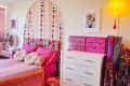 Bedroom with pink bed and storage