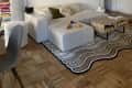 A white sectional sofa with a rug underneath
