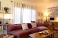 A plum colored camino-sectional-sofa in a living room.