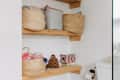 Philadelphia residence with white walls, lots of wood details: wood shelf storage in bathroom with multiple baskets