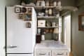 Kitchen with grey-green walls, open shelving, hardwood floors and hexagonal tile