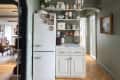 Kitchen with grey-green walls, open shelving, hardwood floors and hexagonal tile