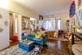 Overview of studio apartment with small blue velvet sofa and canopy bed.