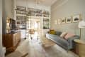 Blue velvet sofa in living room with built in bookcase  that arches over bedroom threshold.