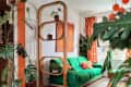 Colorful decorated living room with orange accents and green fabric couch.