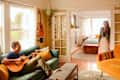 Dweller plays acoustic guitar in living area.