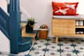 Blue living room with star motif tiles and wooden shoe storage.