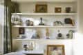 Bookshelf with decorative vases, sculptures, framed art, and books, next to a window with green curtains.