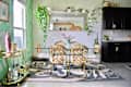Light filled dining room with glass dining table and cantilever dining chairs. Green and white graphic wall treatment decorates room.